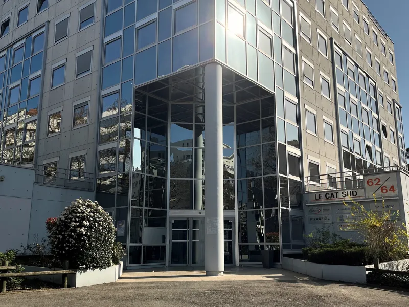 Façade vitrée moderne de l'immeuble de bureaux Le Cat Sud avec entrée sécurisée et accÚs parking.